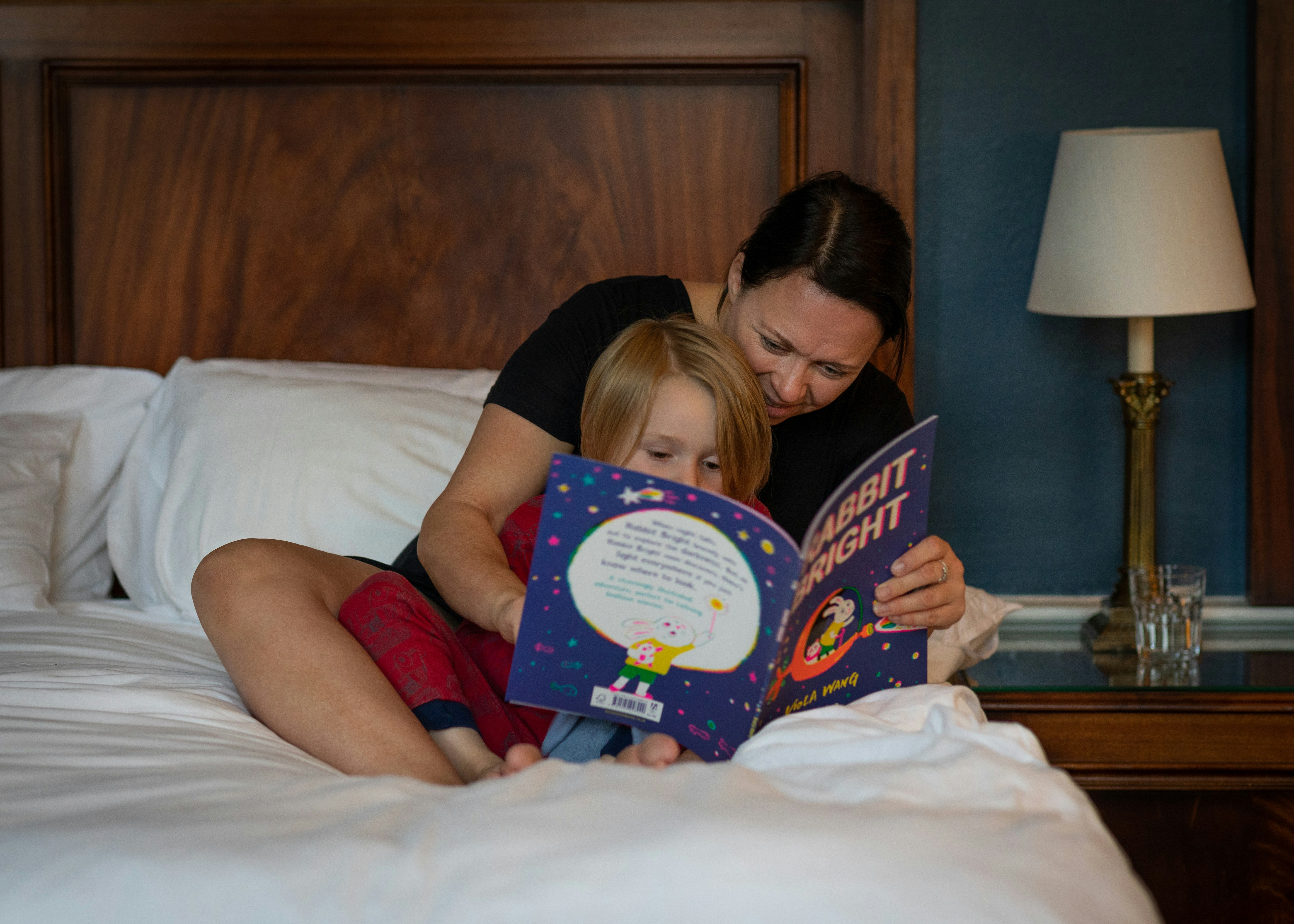 Parent reading bedtime story to child in a cozy setting